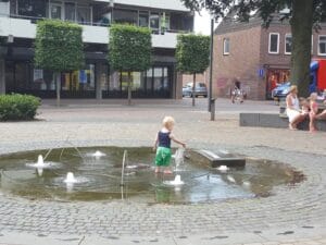 Kind wat speelt in de fontijn bij Koetshuistuin